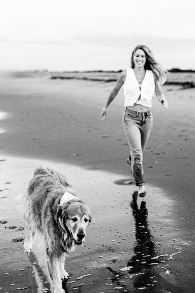 A black and white photo of a mother walking peacefully beside her golden retriever